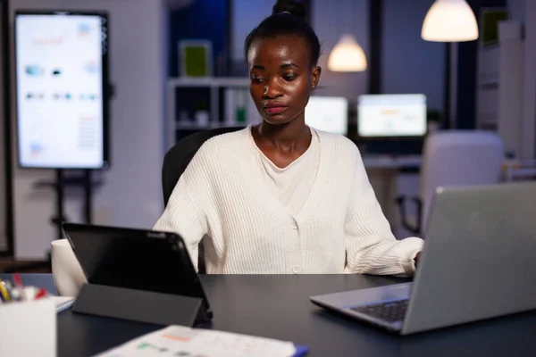 Workaholic fatigué multitâche entrepreneur afro-américain analysant les graphiques financiers — Photo