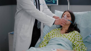 Klinik ekibi hastayı izliyor. Oksijen maskesi takıyor. Solunum durumunu analiz ediyor.