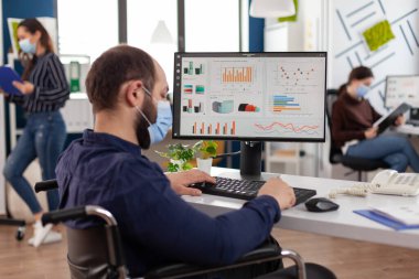 Covid19 'a karşı koruyucu maskeli felçli bir iş adamı.