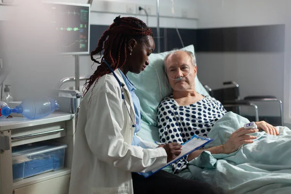 Kranker Senior-Patient liegt im Bett und atmet durch Sauerstoff-Reagenzglas — Stockfoto