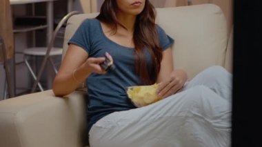 Noel Baba şapkalı kadın Noel arifesinde televizyon izliyor.