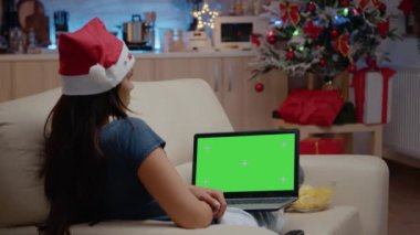 Laptopta yatay yeşil ekrana bakan kadın
