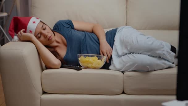 Крупним планом жінка спить на дивані на телебаченні — стокове відео