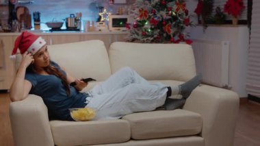 Sıkıcı kadın kanepede uzanıp televizyon izliyor.