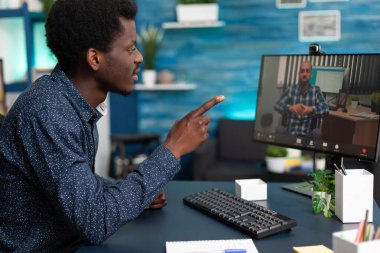 Zenci adam uzaktan engelli öğretmeniyle konuşuyor.