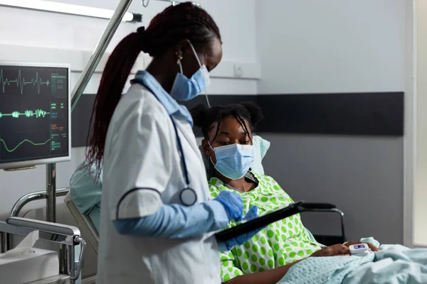 Médecin d'origine africaine aidant un patient malade à la clinique — Photo