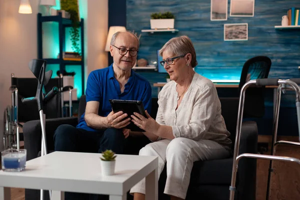 Oud volwassen stel met digitale tablet thuis op de bank — Stockfoto