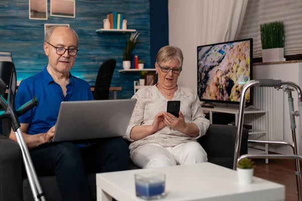 Getrouwde gepensioneerden met technologie thuis — Stockfoto