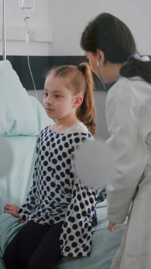 Terapist doktor hasta çocuğa danışıyor. Steteskop takıyor. Kalp atışlarını dinliyor.