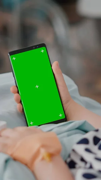Fille malade tenant mock up téléphone à clé chroma écran vert avec affichage isolé pendant la récupération — Photo