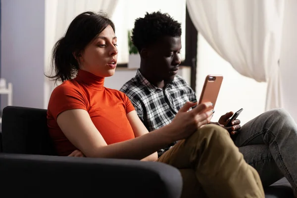 Close up de casal interracial moderno usando smartphones — Fotografia de Stock