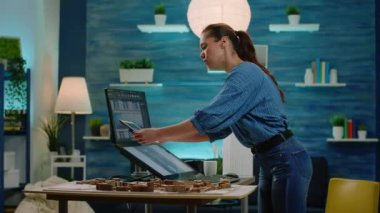 Tablet ve bilgisayarda yapı modelini analiz eden kadın mimar