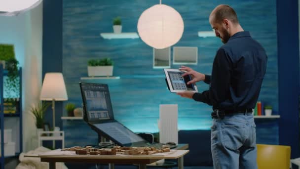 Arquitecto mirando la tableta con el modelo de construcción para el desarrollo — Vídeo de stock