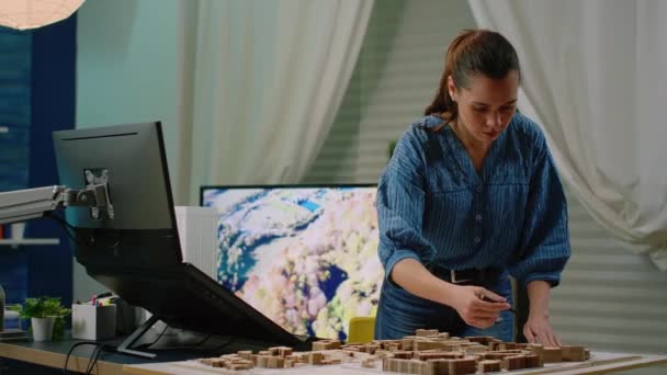 Архитектор держит макет в руке с помощью компьютера с сенсорным экраном — стоковое видео