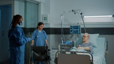 Hasta hasta, hastane koğuşunda tekerlekli sandalyede oturuyor.