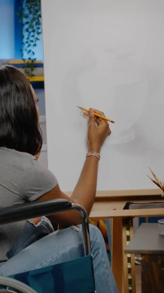 Czarny niepełnosprawny artysta z niepełnosprawnością używając ołówka na płótnie — Zdjęcie stockowe