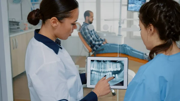 Stomatologo con tablet moderno con raggi X sullo schermo — Foto Stock