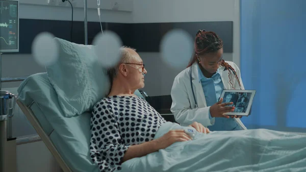 アフリカ系アメリカ人の患者にタブレットでxrayを説明する医療 — ストック写真
