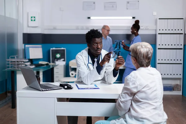 Médecin d'origine afro-américaine tenant une radiographie — Photo