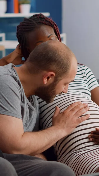 Casal inter-racial esperando criança na sala de estar — Fotografia de Stock