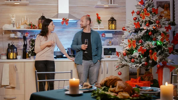 Festive couple standing and clinking glasses of champagne