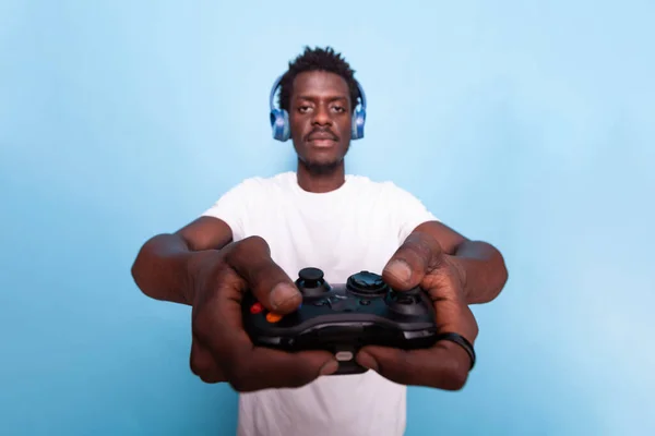 Osoba trzymająca kontroler do gier wideo podczas noszenia słuchawek — Zdjęcie stockowe