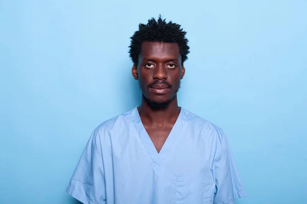 Πορτρέτο του μαύρου άνδρα νοσοκόμα στέκεται πάνω από το μπλε φόντο — Φωτογραφία Αρχείου
