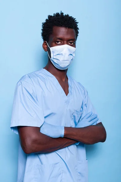 Verpleegster met gekruiste armen met gezichtsmasker en handschoenen — Stockfoto