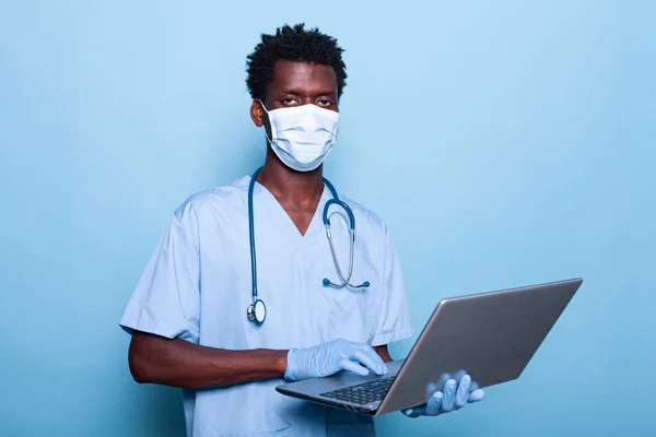 Gezondheidszorg specialist met laptop in de hand op zoek naar camera — Stockfoto
