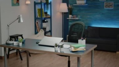 Evde dizüstü bilgisayar ve kahveyle çalışan siyah bir adam.