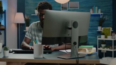 Uzaktan çalışma için bilgisayar kullanan Afrikalı etnik kökenli bir yetişkin.