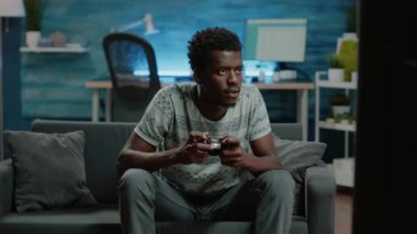 Genç yetişkinler video oyunlarında kaybettiler TV konsolunda joystick ile