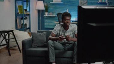 TV konsolunda denetleyici ile video oyunları oynayan adam