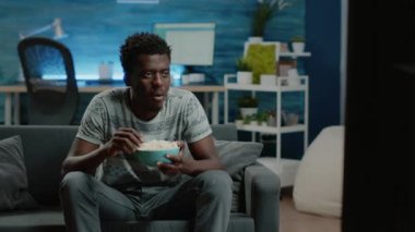 Afrikalı Amerikalı adam televizyonda komediden hoşlanıyor.