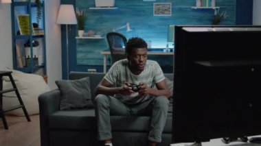 Televizyondaki video oyunlarını kazandıktan sonra gülümseyen kişi