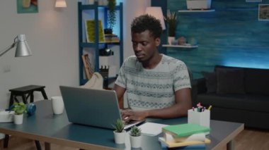 Afrikalı etnik kökenli bir iş adamı bilgisayarını uzaktan kumanda için kullanıyor