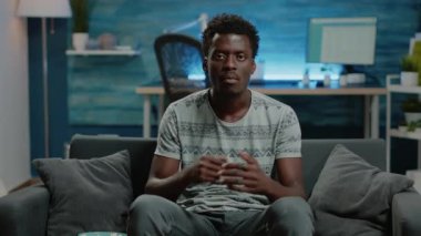 Afrikalı Amerikalı adam televizyonda futbol maçında tezahürat yapıyor.