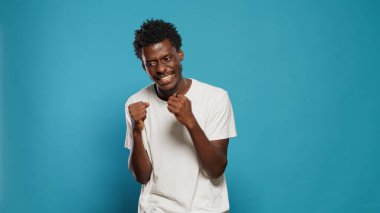 Kızgın adam stüdyoda duygularını gösteriyor ve yumruklarını sıkıyor.