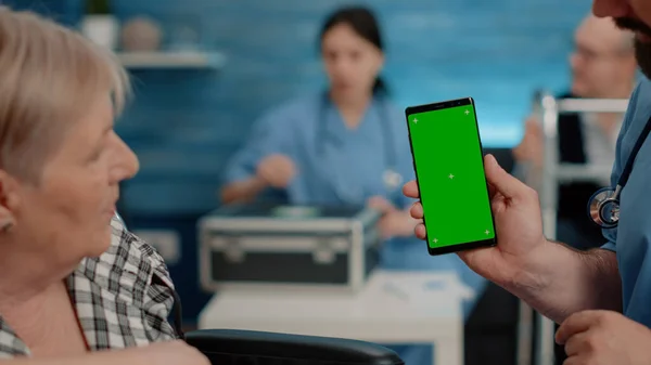 Detailní záběr sestry svisle zobrazující telefon se zelenou obrazovkou — Stock fotografie