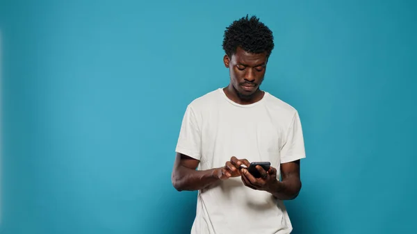 Uomo confuso utilizzando smartphone per messaggi di testo — Foto Stock