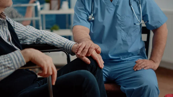 老人を慰める看護師の手を閉じる — ストック写真