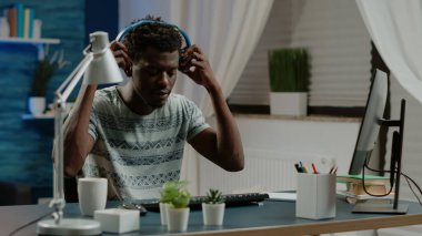 Girişimci klavyede yazı yazıyor ve müzik dinliyor