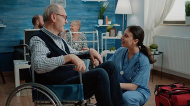 Yaşlı adam kadın hemşire tarafından ziyaret ediliyor.