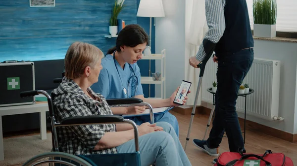 Mulher aposentada e enfermeira conversando com o médico em videochamada — Fotografia de Stock