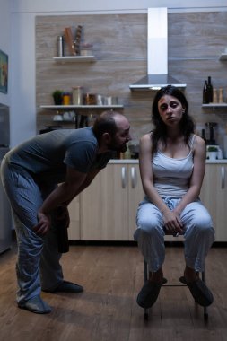 Kızgın şiddet yanlısı bir adam mutsuz bir kadını tehdit ediyor.