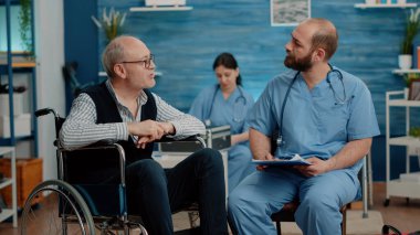 Engelli hasta erkek hemşireyle görüşüyor.