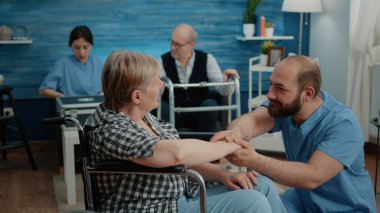 Engelli yaşlı bir kadın hemşireden destek alıyor.