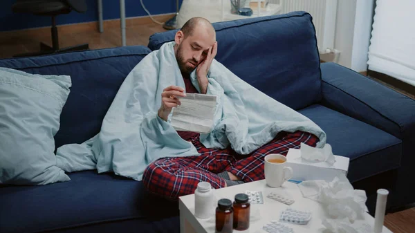 Людина з хворобою читає медичні інформаційні листівки — стокове фото