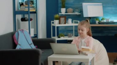 Evde online okul dersleri için dizüstü bilgisayar kullanan küçük çocuk.