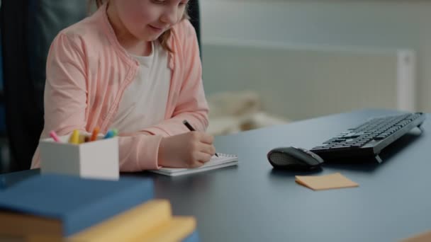 Portrait of schoolgirl using notebook and pen to write homework — Stock Video